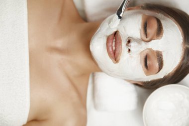 Spa Surat soyma maskesi, kaplıca güzellik tedavisi, cilt bakımı. Güzellik salonundaki kadın yüz bakımı yaptırıyor, yakın plan.