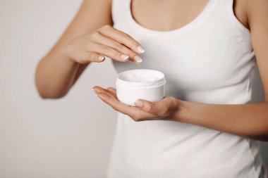 Yakından bir kadın ellerine koruyucu krem sürüyor. El bakımı. Kozmetik kremi. Güzellik ve vücut bakımı kavramı