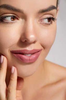 Pürüzsüz Derisi ve İnce Makyajlı Bir Kadının Yakın Çekimi Doğal Güzelliğini Yumuşak, Tarafsız Işık Ayarında Vurguluyor