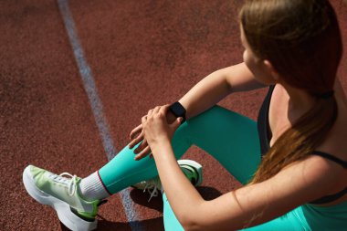 Formda bir kadın spor yaptıktan sonra, canlı bir spor kıyafeti ve şık bir elbise giyer, sağlıklı bir yaşam tarzı ve kararlılığı somutlaştırır. Egzersiz konsepti