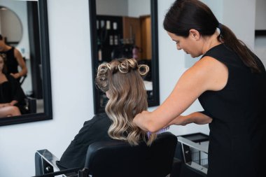 Kuaför kuaför, kuaför koltuğunda oturan bir müşterinin saç stilini yansıtan aynalı bir kuaför..