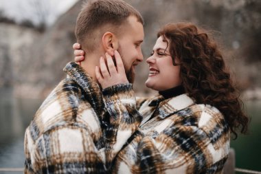 İki insan, kışın Sevgililer Günü 'nde birbirlerine yakın durup gülümseyerek ve romantik bir anın tadını çıkarırlar..