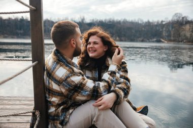 Serin bir günde iki kişi birlikte oturup gülümseyerek kahkaha atar. Bir anlık sevgi ve bağlantının tadını çıkarırlar..