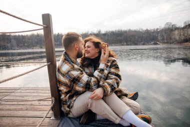 İki insan su kenarında oturup, birbirlerine eşlik ederek ve sevgililer gününde aşklarını kutlayarak eğlenirler..