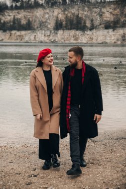 İki insan deniz kenarında romantik bir yürüyüş yapar, Sevgililer Günü 'nde gülümseyerek ve birbirlerine eşlik ederek doğal bir ortamda eğlenirler..