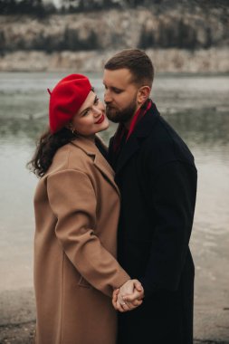 Sevgililer Günü 'nde iki kişi su kenarında bir anı paylaşır. El ele tutuşup gülümseyerek birbirlerine eşlik etmekten hoşlanırlar..