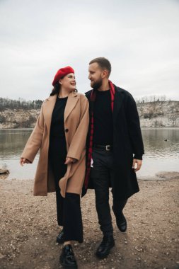 Sevgililer Günü 'nde bir erkek ve bir kadın göl kenarında yan yana yürür. Birlikte eğlenirken birbirlerine gülümserler..