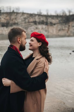Sevgililer Günü 'nde birbirlerine yakın durup, gülümseyen ve kucaklayan iki insan..