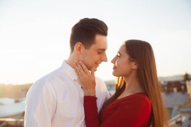 İki insan şehrin batan güneşinin altında çatıda bir anı paylaşır. Birbirlerinin gözlerinin içine bakıp gülümserler..