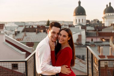 İki kişi bir an için çatıda poz veriyor şehir çatıları ve kubbeli binalar manzaralı..