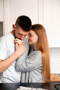 Mutfakta birbirine yakın duran iki insan bir anlık şefkat gösterirler. Yemek hazırlıkları ve sıcak bir atmosferle çevriliyken el ele tutuşup gülümserler..