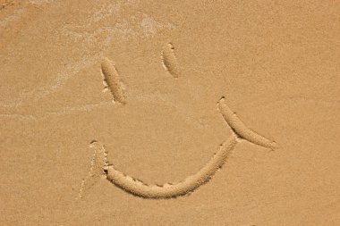 Kumsalda çekilmiş gülen yüz