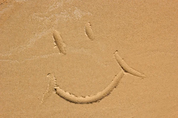 Rosto sorridente desenhado na praia — Fotografia de Stock