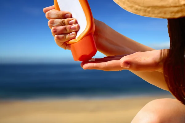 Closeup on hand squeezing sun block creme from a tube — Stock Photo, Image