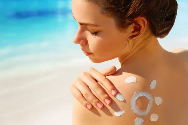 Porträtt av underbara kvinna i bikini med ritade solen på axeln på stranden — Stockfoto