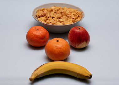 Mısır gevreği, muz ve elma, beyaz arka planda sağlıklı karbonhidratlar.