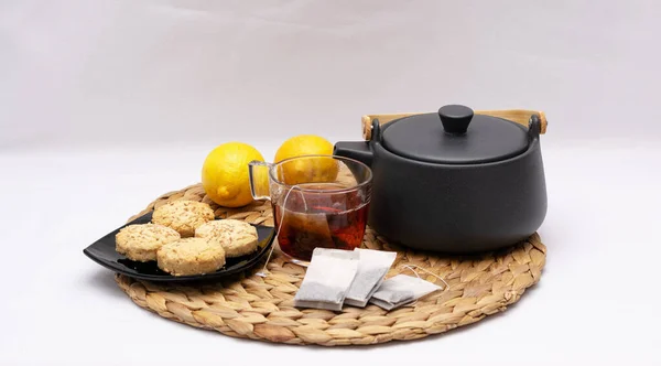 Kırmızı çay fincanı, beyaz kumaş arka planda el yapımı kurabiyeler..