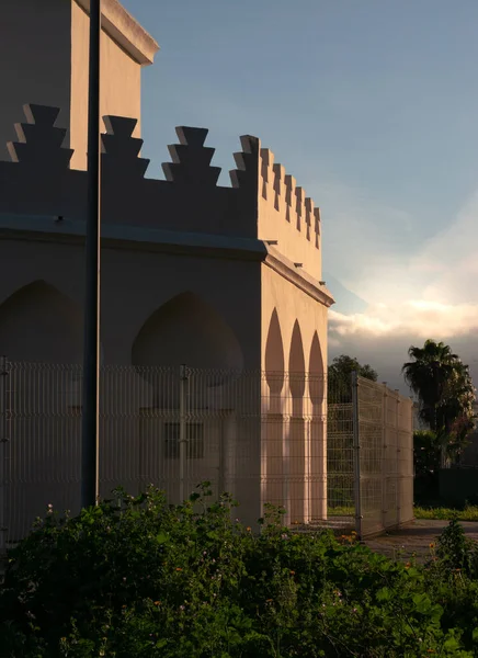 Beyaz Arap kemerli cami mimarisi. Arka planda mavi gökyüzü var.