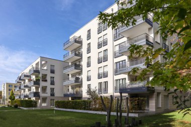 Modern yerleşim alanı olan şehir manzarası, yeni apartmanlar ve sonbaharda yaya geçidi ve ağaçları olan yeşil avlu.