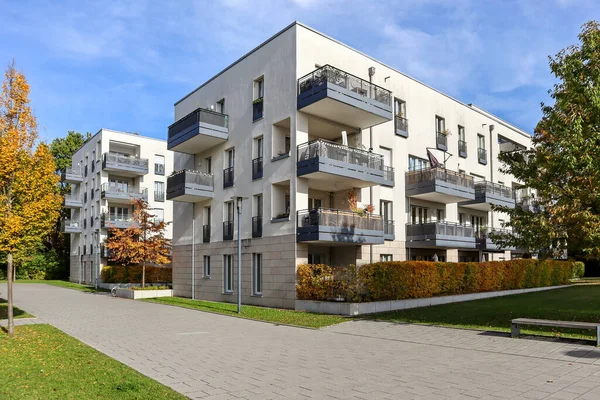 Modern yerleşim alanı olan şehir manzarası, yeni apartmanlar ve sonbaharda yaya geçidi ve ağaçları olan yeşil avlu.