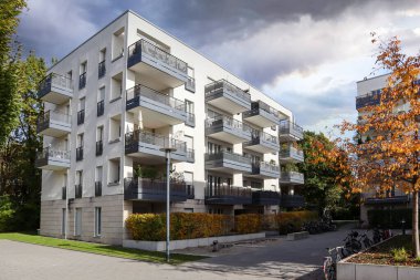 Modern yerleşim alanı olan şehir manzarası, yeni apartmanlar ve sonbaharda yaya geçidi ve ağaçları olan yeşil avlu.