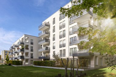 Modern yerleşim alanı olan şehir manzarası, yeni apartmanlar ve sonbaharda yaya geçidi ve ağaçları olan yeşil avlu.