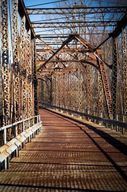 Yaşlı paslı, tek şeritli köprü nehrin üzerinde..