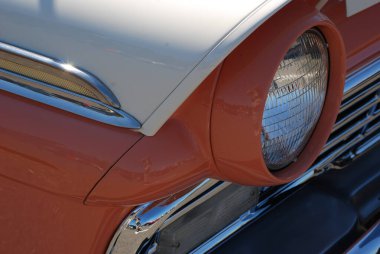 1960 model turuncu ve beyaz boyalı bir Buick 'in far detayı..