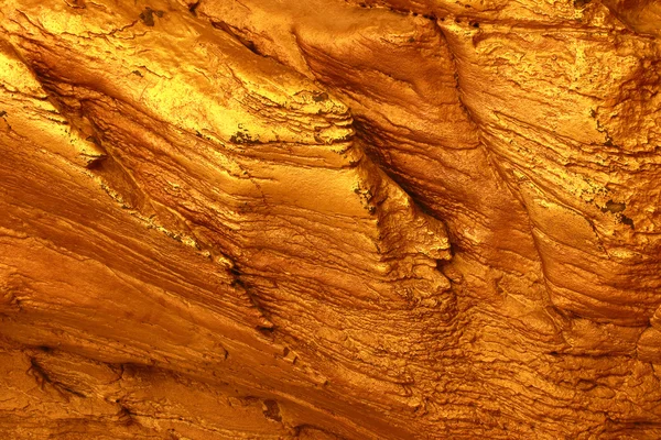 Pared de oro de piedra, primer plano textura de fondo de piedra de color oro — Foto de Stock