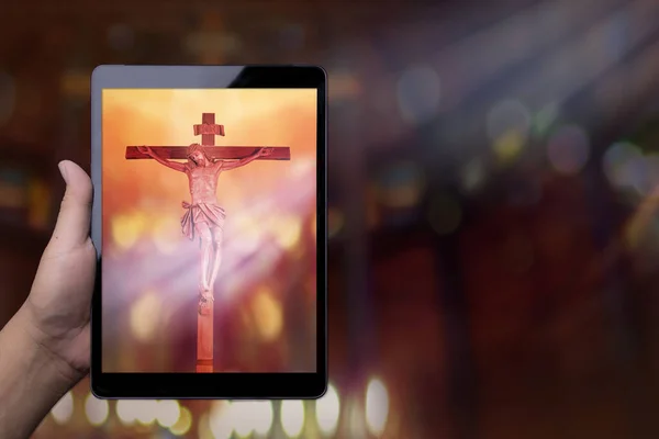 クロスイエスと手のタブレット画面を保持します 教会サービスのホームストリーミングからの礼拝 精神的な宗教オンラインコンセプト Covid 19状況 — ストック写真