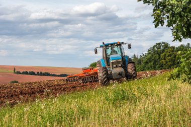 Bir sahada çalışan traktör çiftçi