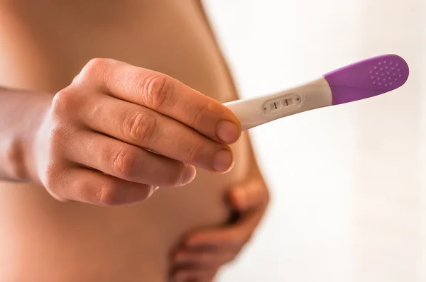 Pregnant woman holding positive pregnancy test — Stock Photo, Image