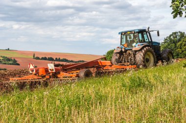 Bir sahada çalışan traktör çiftçi