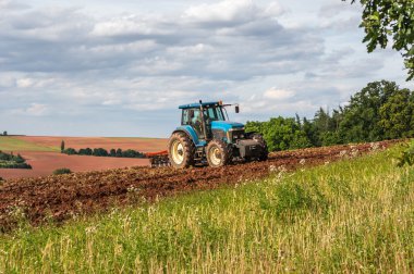 Bir sahada çalışan traktör çiftçi