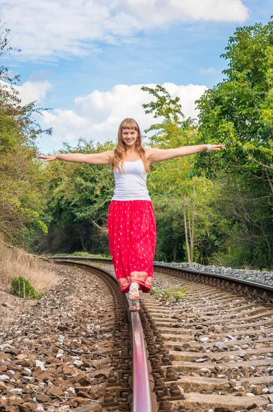 Jeune femme marchant sur les rails — Photo