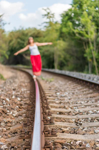 Jovencita caminando por las vías del tren — Foto de Stock