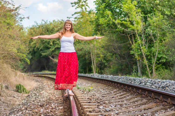 Jeune femme marchant sur les rails — Photo