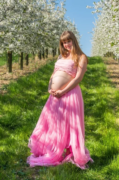 怀孕的年轻女孩，在花园里 — 图库照片