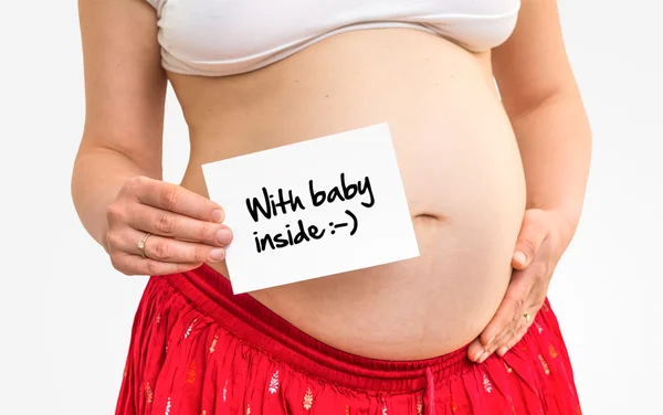 Kobieta w ciąży z napisem: Baby wewnątrz — Zdjęcie stockowe