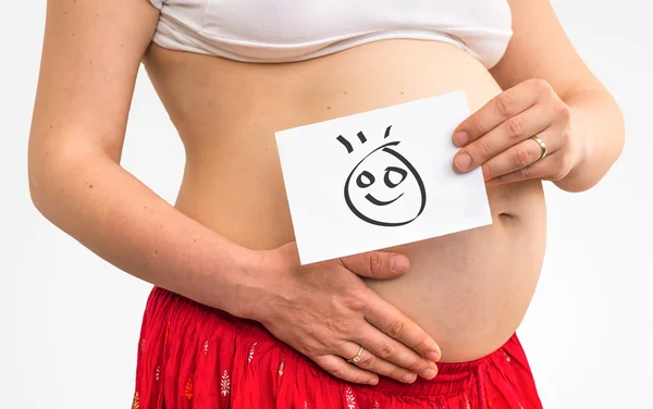 Bauch einer schwangeren Frau und bemaltes Baby — Stockfoto