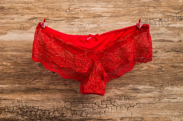 Red sexy panties attached to rope with clothespins — Stock Photo, Image