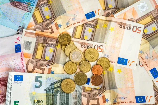 Euro-Banknoten und Münzen auf dem Tisch verstreut — Stockfoto