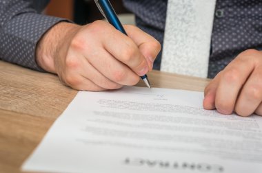 İşadamı bir anlaşma sonuçlandırmak için bir sözleşme imzalama