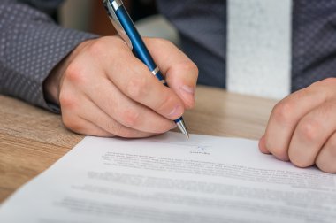 İşadamı bir anlaşma sonuçlandırmak için bir sözleşme imzalama