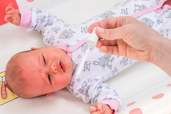 Recém-nascido recebe gotas nasais com solução salina — Fotografia de Stock