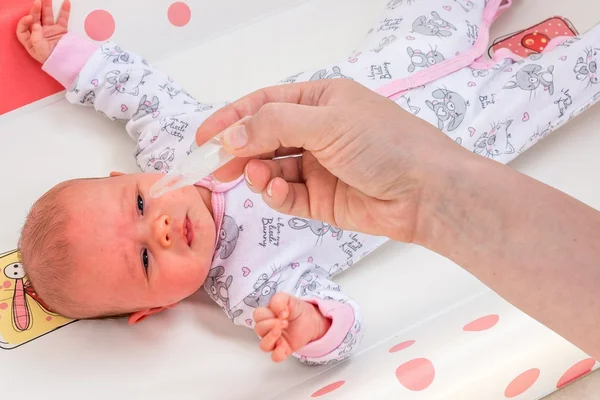 Recém-nascido recebe gotas nasais com solução salina — Fotografia de Stock