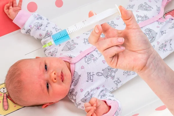 Doctor holds syringe to vaccinate newborn baby — Stock Photo, Image