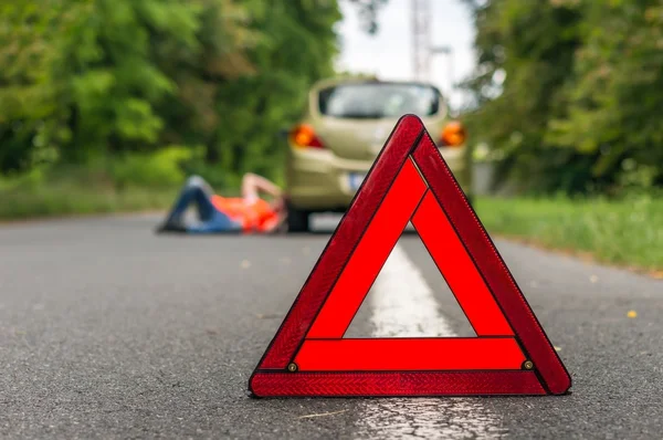 Driver lying under the broken car — Stock Photo, Image