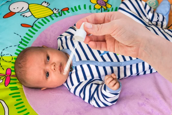 Newborn gets nose drops with saline solution — Stock Photo, Image