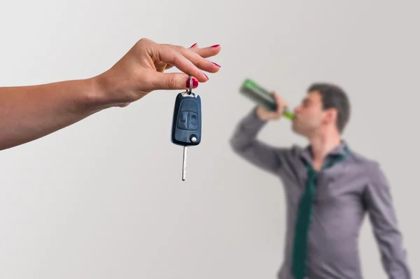 Wife showing car keys and her husband drinking alcohol — Stock Photo, Image